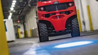 Stivuitoarele cu contragreutate de la Linde cu sistem BlueSpot proiectează un punct albastru de avertizare pe podeaua halei