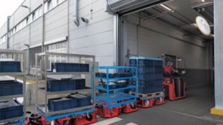 Trenul logistic LT10 WX de la Linde MH transportă materiale între două hale