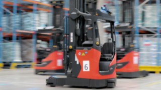 Trei stivuitoare automatizate cu catarg retractabil din seria R-MATIC de la Linde MH în acțiune.