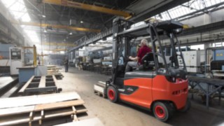 Stivuitoarele Linde Material Handling vor continua să stabilească noi standarde în ceea ce privește ergonomia și confortul operatorului. Un grup de persoane analizează mediul de lucru într-o hală logistică.
