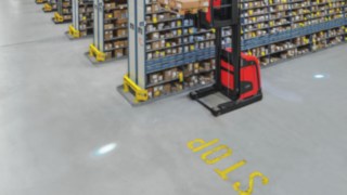 Linde Blue Spot proiectează un punct albastru de lumină pe pardoseală în direcția de deplasare și avertizează pietonii și alți operatori cu privire la echipamentul care se apropie. Imagine cu Linde BlueSpot, care proiectează un punct luminos albastru pe pardoseală, avertizând pietonii sau alți operatori cu privire la echipamentul care se apropie