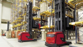 Două stivuitoare K pentru culoare foarte înguste, de la Linde Material Handling, se deplasează printre rafturile înalte