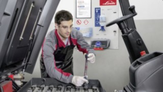 Un tehnician de service verifică bateria de acționare a unui stivuitor second-hand Linde