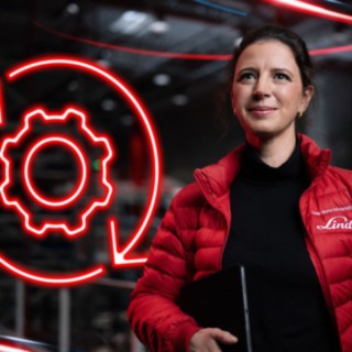 O angajată a companiei Linde Material Handling într-un depozit, cu un simbol roșu luminos reprezentând o roată dințată în fundal.