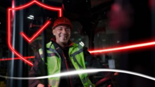 Persoană purtând haine de lucru și cască de protecție, aflată într-un stivuitor Linde