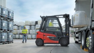 Inteligența artificială a camerei înregistrează pietonii din apropierea stivuitorului și este optimizată pentru persoanele care poartă îmbrăcăminte de lucru și de protecție. Linde X25 la încărcarea unui camion în incinta unei fabrici, în spate un pieton în haine de lucru