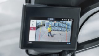 Reverse Assist Camera asistată de AI extinde câmpul vizual. Afișajul Reverse Assist Camera indică un pieton