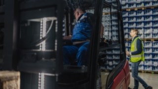 Un operator întâlnește în timpul deplasării în marșarier cu un electrostivuitor Linde X30 o persoană care este detectată de Reverse Assist Radar.