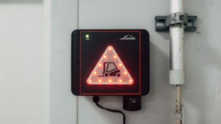 Distanțele dintre unitățile de pe stivuitor și uși sunt determinate cu o precizie de zece centimetri. Unitatea Linde Door Control instalată permanent pe ușa de mare viteză