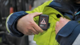 Angajații DB Schenker poartă unitatea portabilă Linde Safety Guard