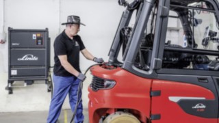 Bateria Linde Li-ION de înaltă performanță alimentează stivuitoarele X35. Angajatul încarcă stivuitorul electric X35, de la Linde