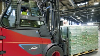 Stivuitorul electric E80 de la Linde Material Handling transportă un palet de bere Heineken.