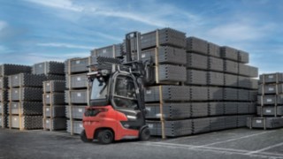 Stivuitorul electric Linde Xi20 PH se află în aer liber încărcând țevi.