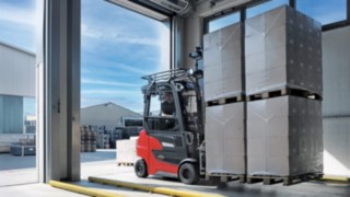 Stivuitorul electric Xi20 PH de la Linde Material Handling transportă mărfurile din depozit în exterior.