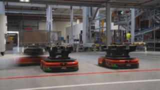 Trei roboți mobili autonomi (AMR) de la Linde MH circulă prin depozit