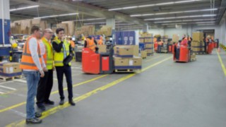 Linde Safety Scan este utilizat la locație. Trei persoane analizează cazuri într-o hală din fabrică.