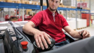 Un operator pune mâna pe joystick-ul multifuncțional de la Linde Material Handling