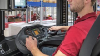 Un operator acționează joystick-ul multifuncțional într-un utilaj de la Linde Material Handling